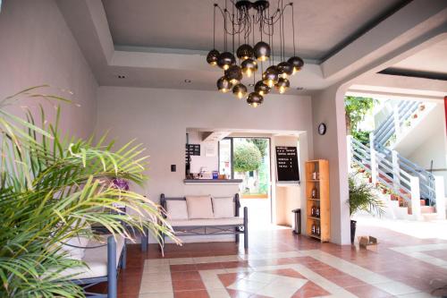a living room with a couch and a chandelier at Marqués Oaxaca - Hotel in Oaxaca City