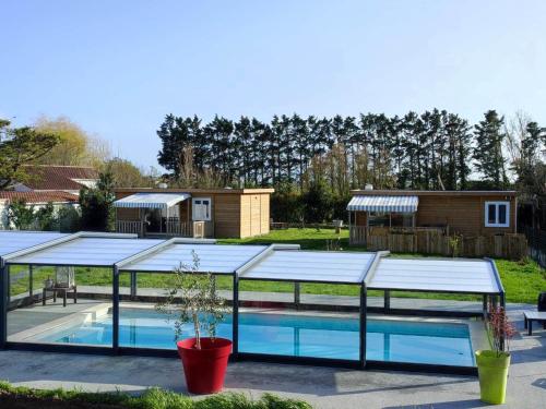 - une piscine avec un pavillon à côté d'une maison dans l'établissement Chalet colonids 2, à Grues