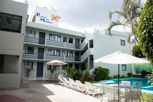 un hôtel avec des chaises et des tables ainsi qu'une piscine dans l'établissement Marqués Oaxaca - Hotel, à Oaxaca