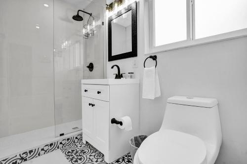 a white bathroom with a toilet and a shower at Outdoor Paradise in Fort Lauderdale