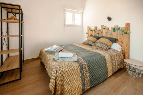 a bedroom with a large bed with a wooden headboard at Loft du Pain avec SPA privatif in Druye
