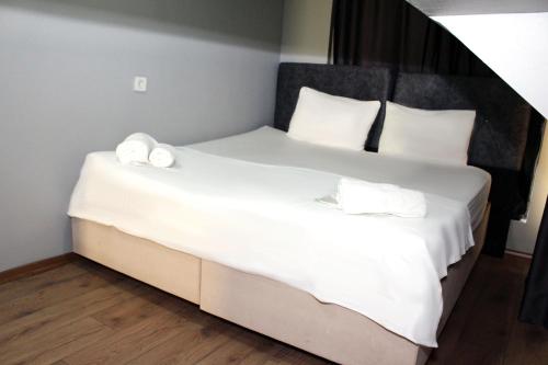 een slaapkamer met een bed met witte lakens en handdoeken bij Avist Hotel Avcılar in Avcılar