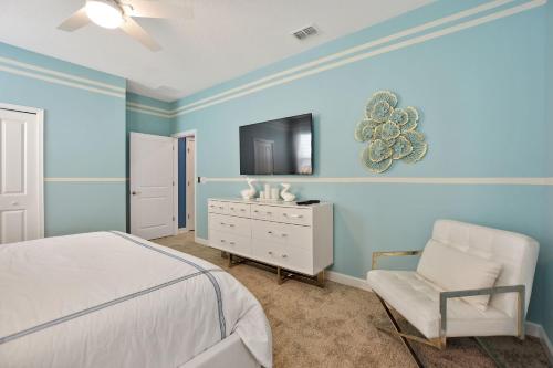 a bedroom with a bed and a chair and a tv at Luxury Villa near Disney 8 Bedroom Private Pool & Playground1 in Kissimmee