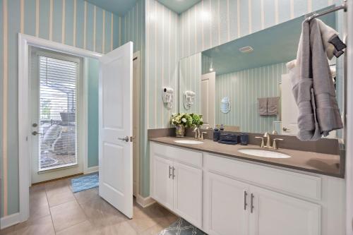 a bathroom with two sinks and a mirror at Luxury Villa near Disney 8 Bedroom Private Pool & Playground1 in Kissimmee