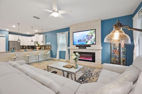 a living room with a white couch and a tv at Luxury Villa near Disney 8 Bedroom Private Pool & Playground1 in Kissimmee