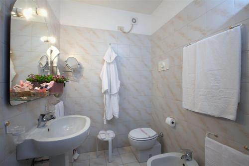 bagno bianco con lavandino e servizi igienici di Hotel City a Piacenza