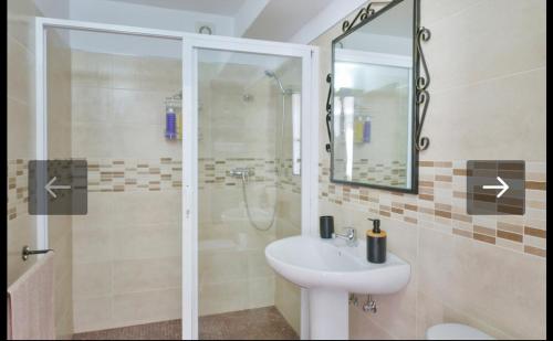 a bathroom with a sink and a shower with a mirror at Casa la limosna in Setenil