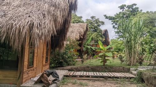 a house with a thatched roof and a wooden porch at Ecohab -Parque Tayrona in Santa Marta