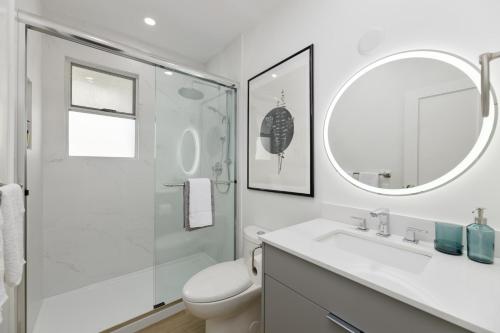 a bathroom with a toilet and a sink and a mirror at Spacious Fully Furnished 2-BR Suite in Vancouver