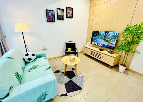 a living room with a blue couch and a television at Netflix-Seaview-SunsetView-PuteriBeach-Mutiara Beach Resort Melaka in Kampong Pantai Dusun