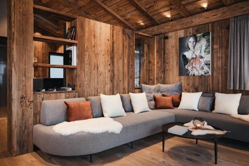 a living room with a couch and wooden walls at Luxury Spa Chalet Lum d'Or in Selva di Val Gardena