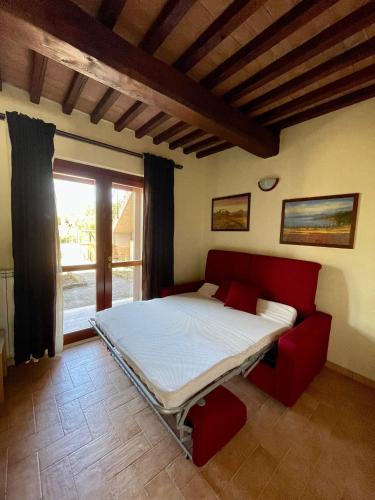 a bedroom with a bed in a room with a window at Saturnia House in Poggio Murella