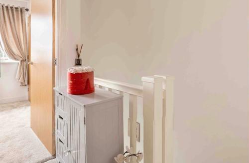 a red cake sitting on top of a white cabinet at Fullers Modern and Stylish Room in Chudleigh