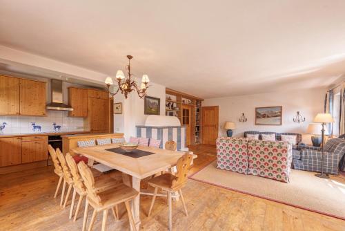 a kitchen and living room with a wooden table and chairs at Chalet Windegg in Sankt Anton am Arlberg