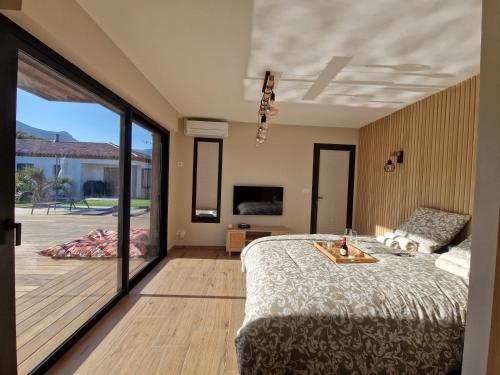 a bedroom with a bed and a sliding glass door at The Pool house in La Farlède