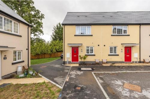 a house with red doors in a parking lot at Fullers Modern and Stylish Room in Chudleigh