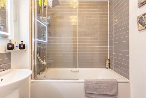a bathroom with a bath tub and a sink at Fullers Modern and Stylish Room in Chudleigh