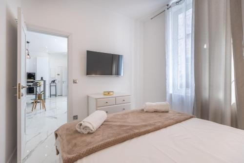 um quarto branco com uma cama e uma televisão na parede em Renovated Apt Min. from Beach/Palais - 30m2 Terrace em Cannes