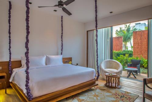 a bedroom with a swinging bed and a patio at Azaya Beach Resort Goa in Benaulim