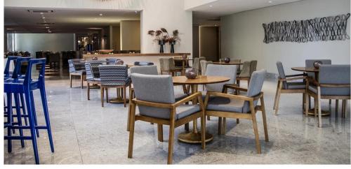 un ristorante con tavoli e sedie in una stanza di BEACH CLASS RECIFE BOA VIAGEM FLAT ANDAR ALTO a Recife