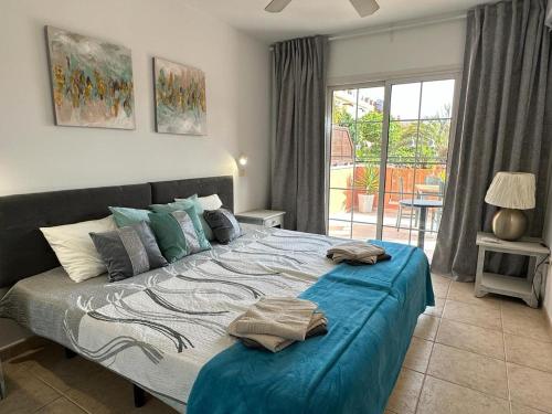 1 dormitorio con 1 cama grande con sábanas azules en Sunny Apartment & Heated pool, en Los Cristianos