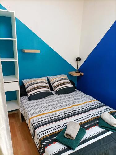 un lit dans une chambre avec un mur bleu dans l'établissement T2 Intra-Muros 
