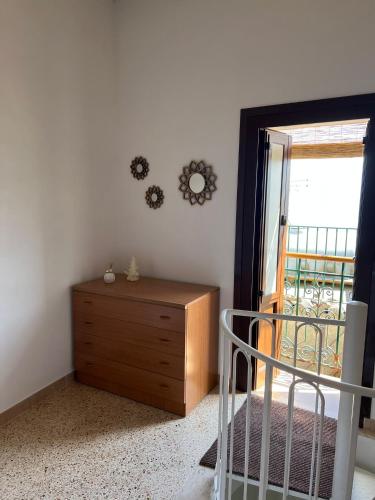 a bedroom with a dresser and a door to a balcony at La Chiocciola - Casa vacanze in Erice