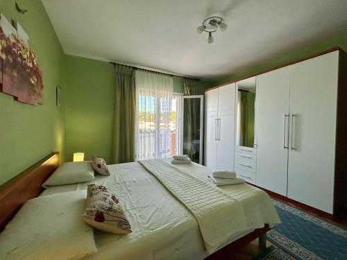 a bedroom with a large bed with green walls at Apartments Korta in Račišće