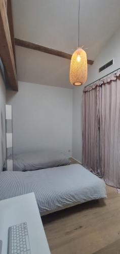 1 dormitorio con cama, lámpara y ordenador portátil en Maison village Camargue 4/6 pers, en Aimargues