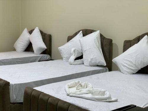 two beds with white sheets and a stuffed animal on them at رويال ماجيك in Cairo