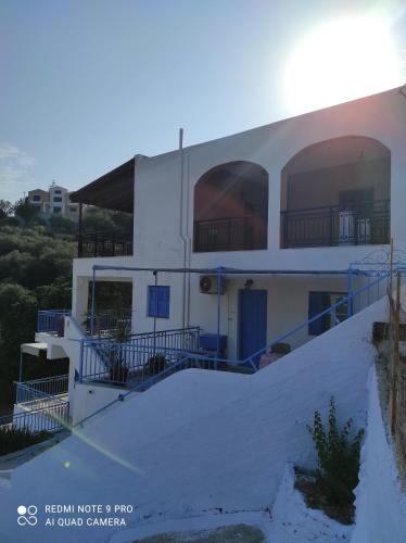 a white house with blue railing on the side of it at Valentino in Kalymnos