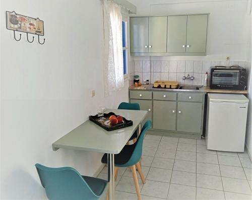 a kitchen with green cabinets and a table and chairs at Valentino in Kalymnos