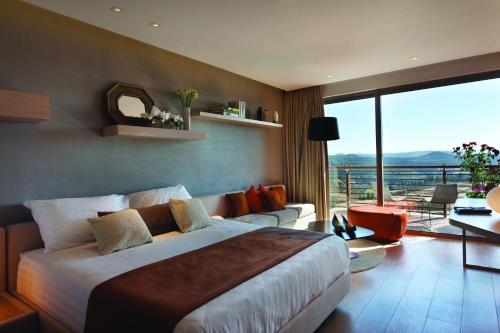 a bedroom with a large bed and a balcony at Cramim by Isrotel Exclusive in Qiryat ‘Anavim