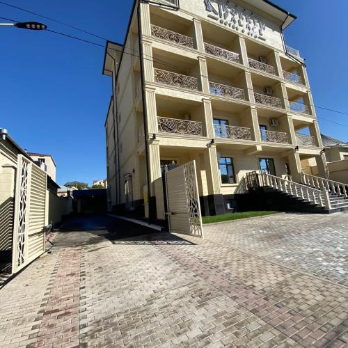 un gran edificio con una puerta delante en KORKEM Palace Hotel and Spa en Shymkent