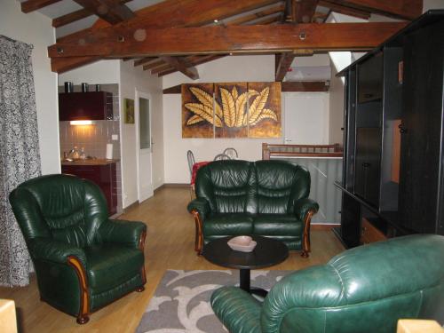 a living room with two leather chairs and a table at Faubourg St Jean in Aubeterre-sur-Dronne