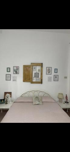 - une chambre avec un lit et des photos sur le mur dans l'établissement Casa in centro, à Augusta