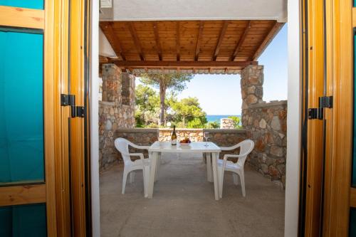 een tafel en stoelen op de veranda van een huis bij George Seaside Serviced Studios & Apartments in Pefki Rhodes