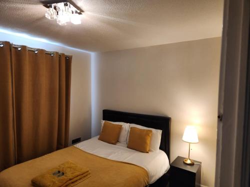 una piccola camera da letto con letto con cuscini gialli di Home away from Home a Woolwich