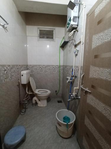 a small bathroom with a toilet and a shower at Malwade Motel in Pune
