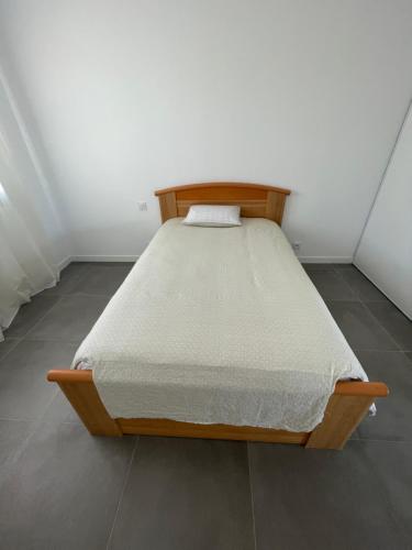 a wooden bed in a room with a white wall at Magnifique villa haut standing in Gignac