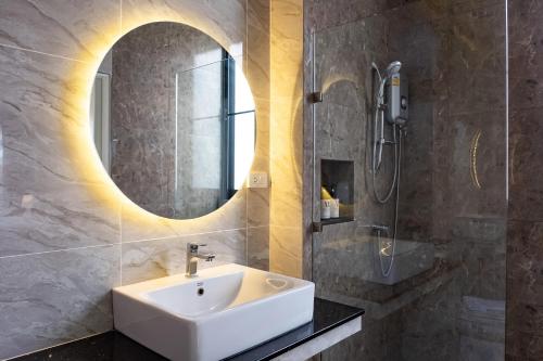 a bathroom with a sink and a mirror at Wellington Hotel Prachuapkhirikhan in Ban Nong Bua