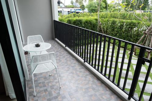 a balcony with two chairs and a table and a table at Wellington Hotel Prachuapkhirikhan in Ban Nong Bua