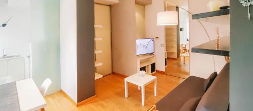 a living room with a couch and a tv at [Centro storico] Luminoso spazio al Piazzo in Biella