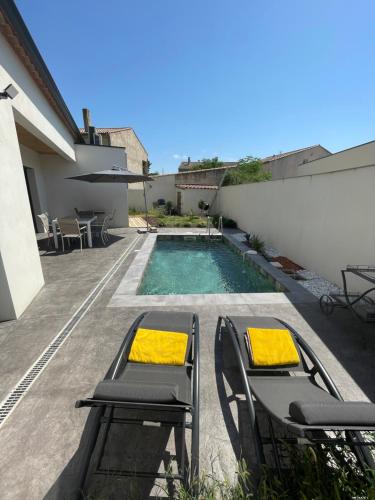 un patio avec des chaises et une piscine dans l'établissement Magnifique villa haut standing, à Gignac