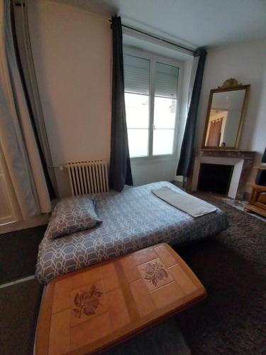 een kleine slaapkamer met een bed en een raam bij Fleurs de lotus 1 in Romilly-sur-Seine
