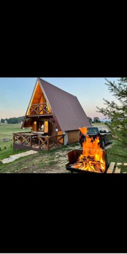 a fire in front of a log cabin at Mountain house Drveni Raj in Žabljak