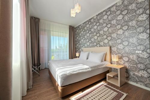 Tomis Garden Aparthotel Mamaia tesisinde bir odada yatak veya yataklar