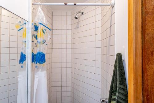a white tiled shower with a shower curtain in a bathroom at Temporada Bacana - Copacabana e Conforto in Rio de Janeiro