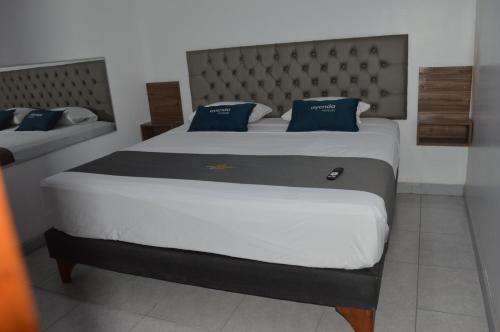 1 dormitorio con 2 camas y almohadas azules en Ayenda Casa Aika Sucre, en Lima