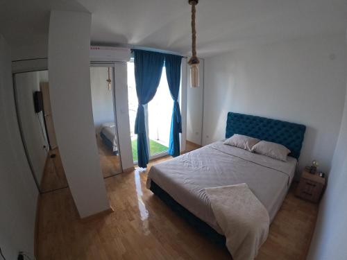 a bedroom with a bed and a large window at Bella Lux Centar in Mladenovac